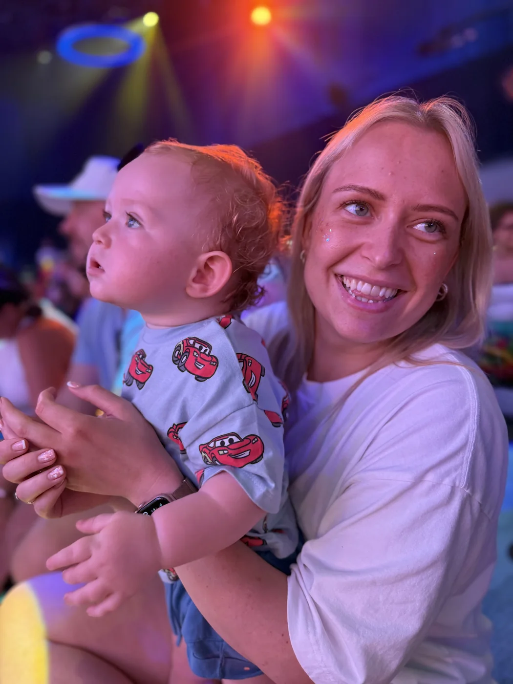 Jodie holding George as they watch the colourful Mickey Mouse Clubhouse show